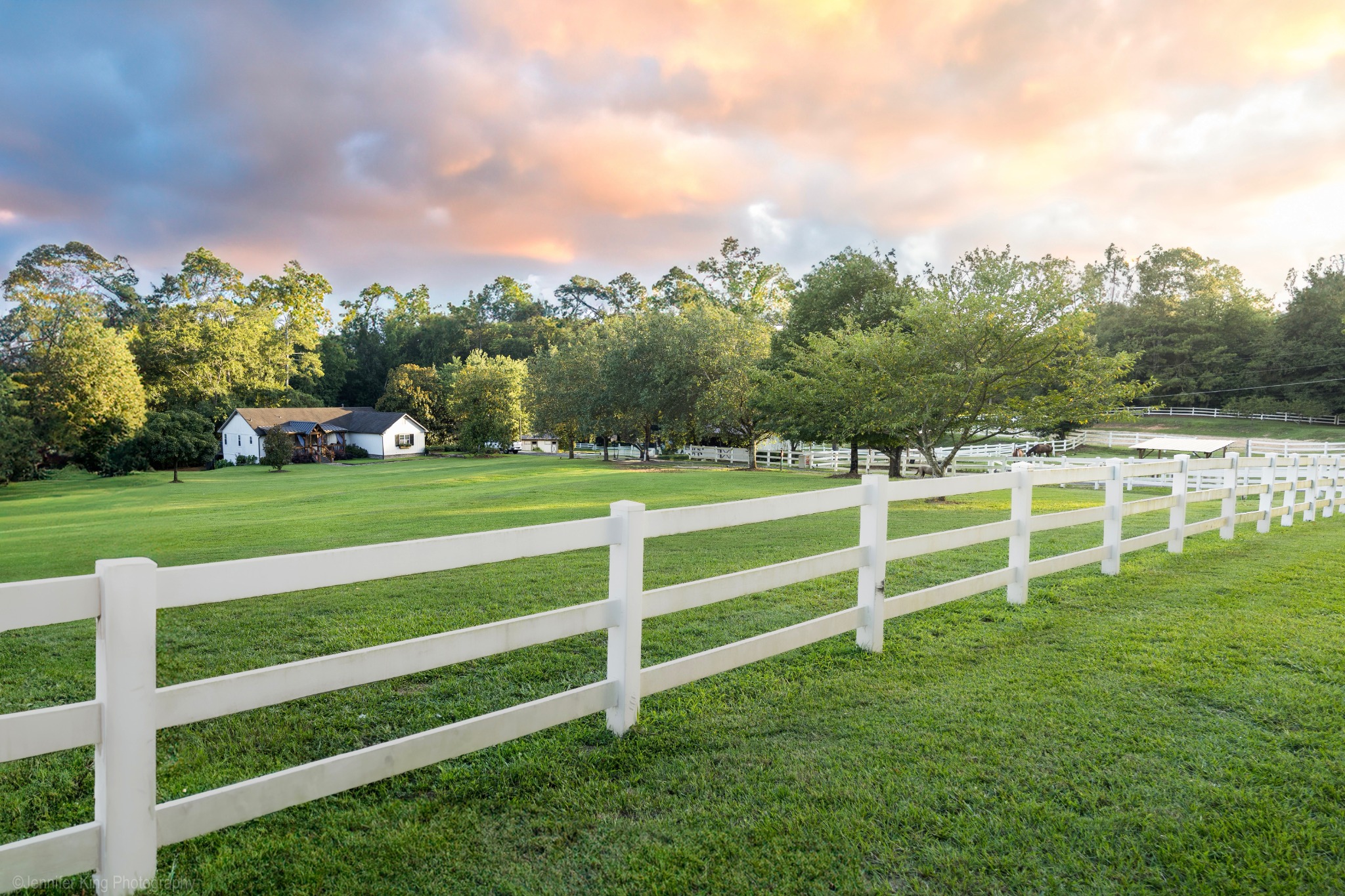 White-fenced pasture at sunset